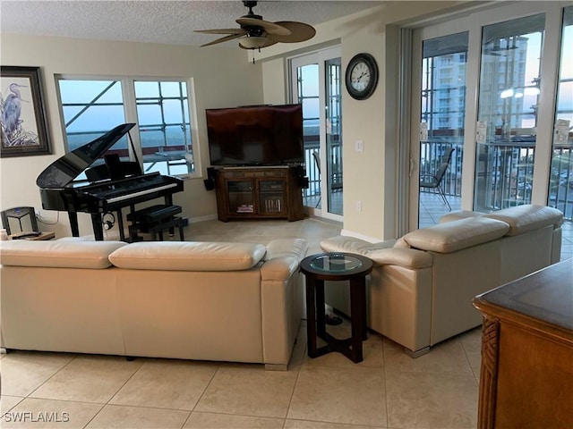 tiled living room with ceiling fan and a textured ceiling