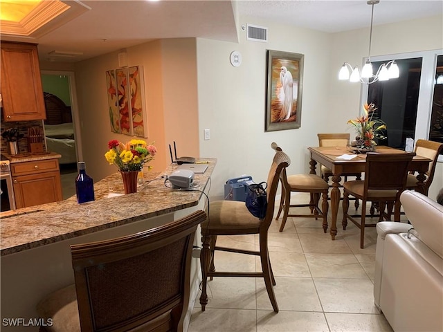 dining space with light tile patterned flooring and a chandelier