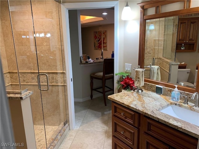 bathroom featuring vanity, tile patterned flooring, a shower with door, and toilet