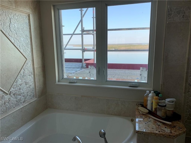 bathroom featuring a water view and a bath