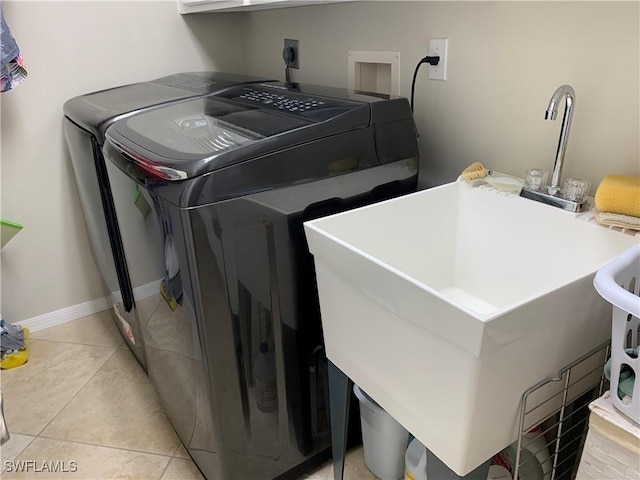 laundry area with separate washer and dryer, light tile patterned floors, and sink