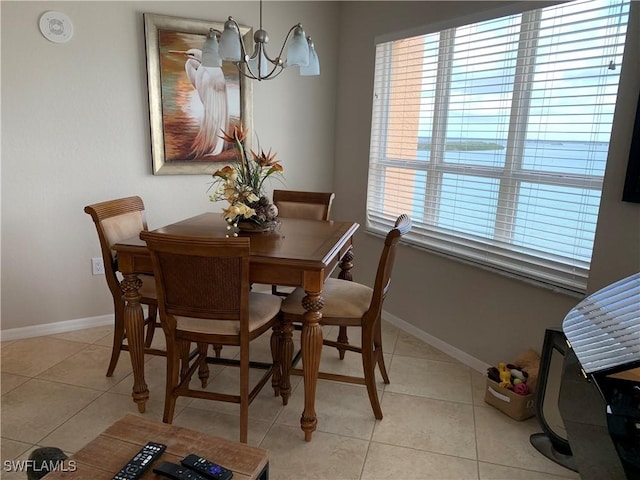 tiled dining room featuring a chandelier