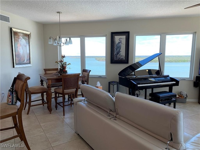 living area featuring light tile patterned floors, visible vents, and a healthy amount of sunlight