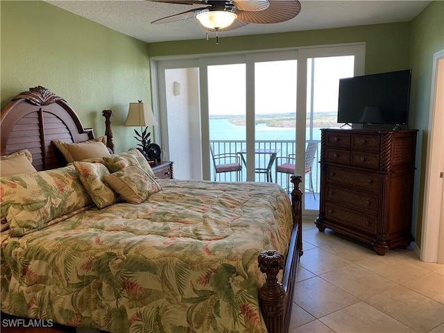 bedroom featuring a ceiling fan, access to outside, light tile patterned flooring, and a textured ceiling