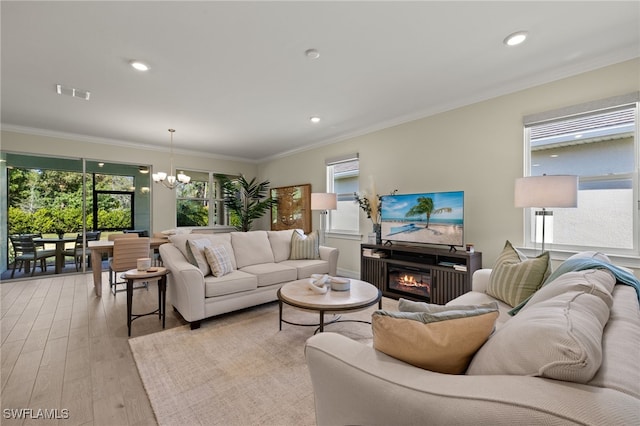 living room featuring ornamental molding, a chandelier, and light wood-type flooring