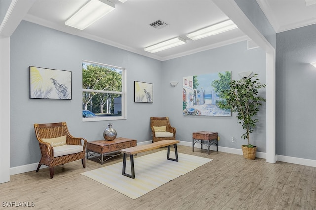 living area featuring ornamental molding and light wood-type flooring