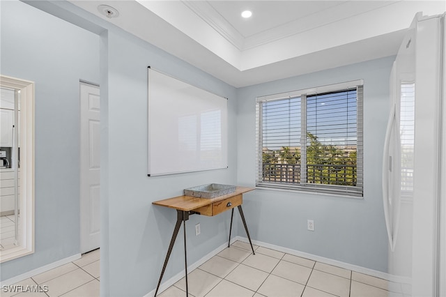 interior space with light tile patterned floors, a tray ceiling, and ornamental molding