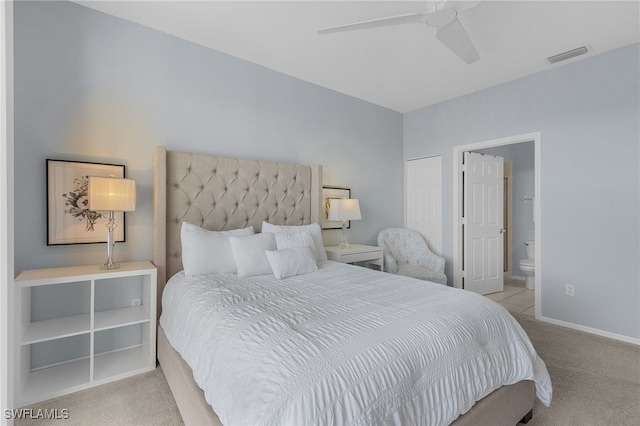 bedroom featuring light colored carpet, ceiling fan, and ensuite bathroom