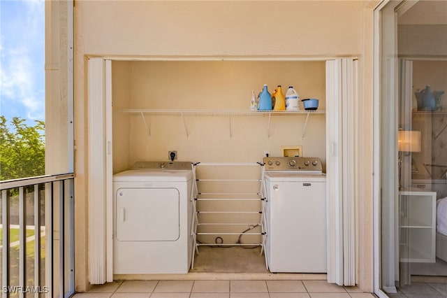 laundry area featuring separate washer and dryer and light tile patterned flooring