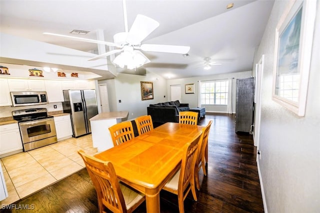 dining room with ceiling fan, lofted ceiling, and light hardwood / wood-style floors