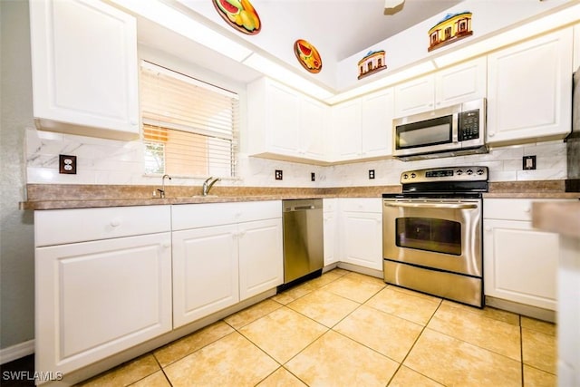 kitchen featuring sink, light tile patterned floors, white cabinets, and appliances with stainless steel finishes