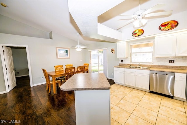 kitchen featuring white cabinetry, a healthy amount of sunlight, vaulted ceiling, and dishwasher