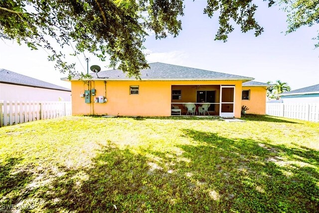 rear view of property featuring a yard and a sunroom