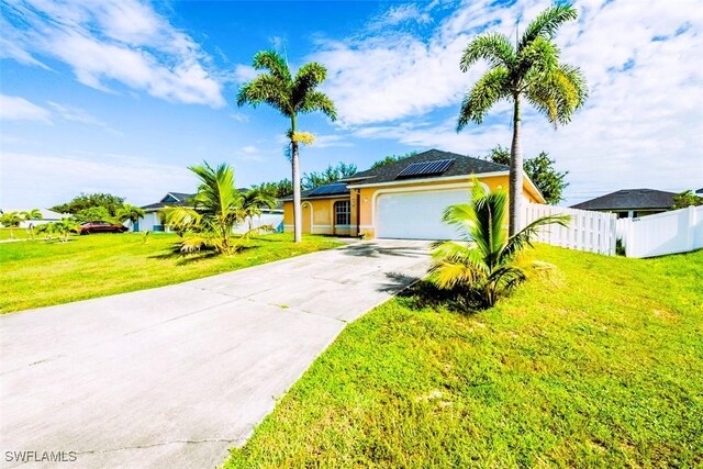 501 NE 24th Ter, Cape Coral, FL 33909 - ranch-style home featuring a garage, a front lawn, and solar panels