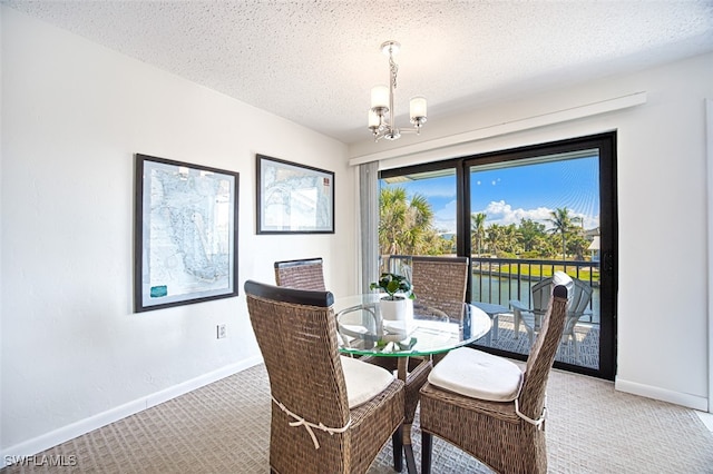 carpeted dining room featuring a water view, a chandelier, and a textured ceiling