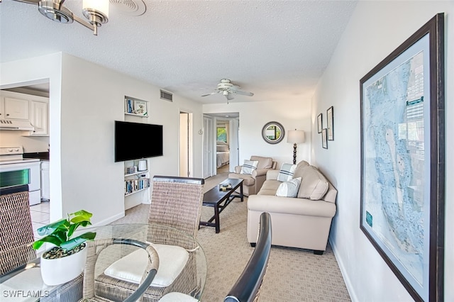 living room with ceiling fan, a healthy amount of sunlight, and a textured ceiling