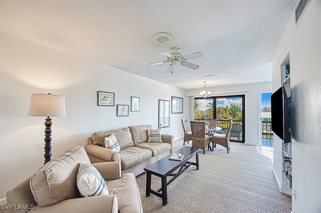 carpeted living room with ceiling fan with notable chandelier and a textured ceiling