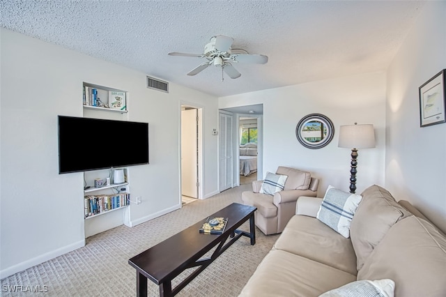 carpeted living room with ceiling fan and a textured ceiling