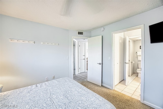 bedroom featuring light carpet and a textured ceiling