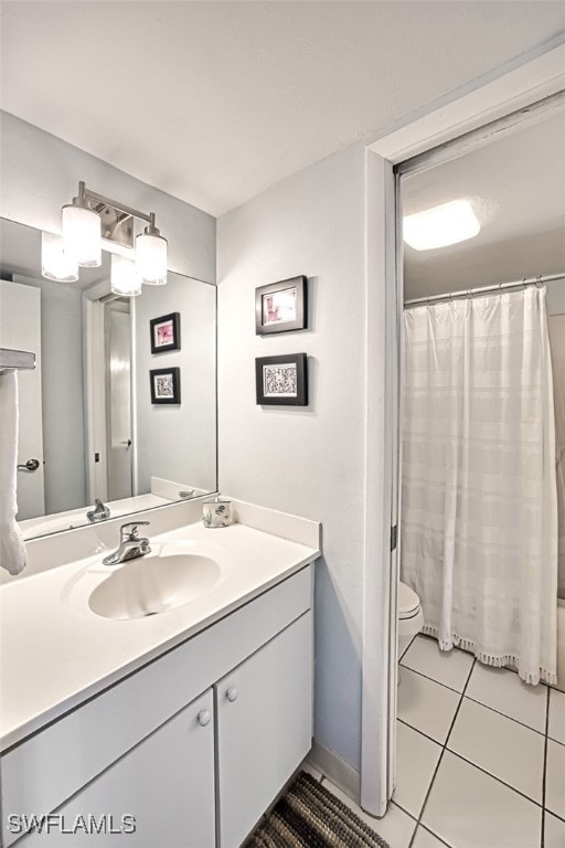 bathroom featuring walk in shower, vanity, toilet, and tile patterned flooring