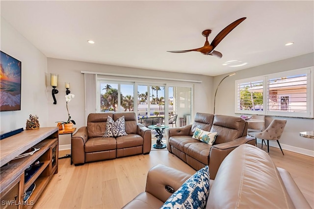 living room with a wealth of natural light, ceiling fan, and light wood-type flooring