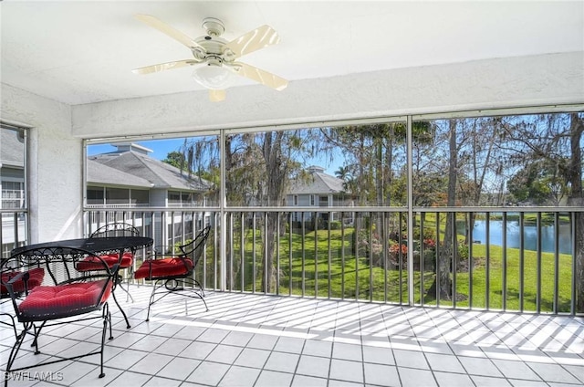 sunroom / solarium featuring a water view and ceiling fan