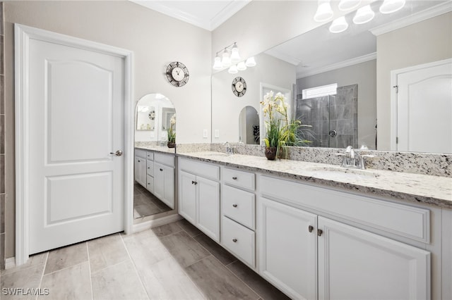 bathroom with vanity, crown molding, and tiled shower