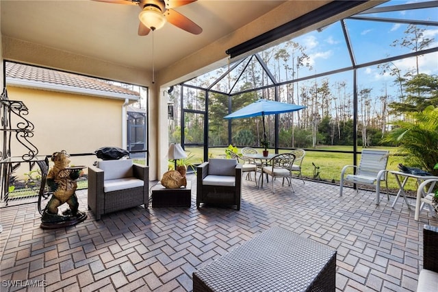 view of patio with an outdoor living space, a lanai, and ceiling fan