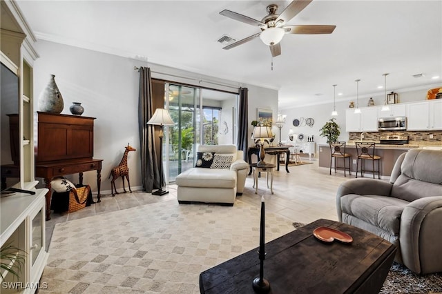 living room with ceiling fan and ornamental molding