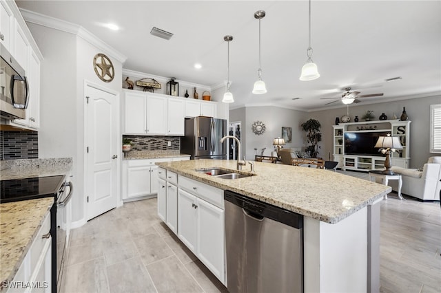 kitchen featuring sink, appliances with stainless steel finishes, a kitchen island with sink, white cabinetry, and hanging light fixtures