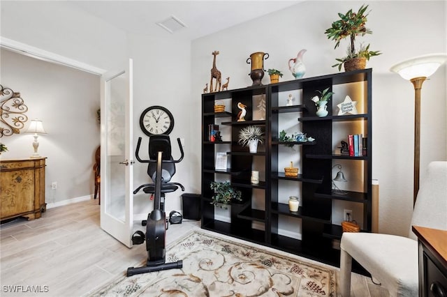 exercise room featuring french doors and light hardwood / wood-style floors