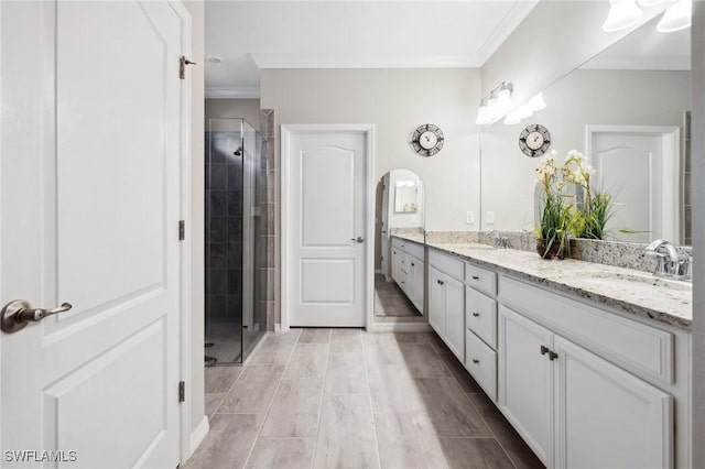 bathroom featuring crown molding, vanity, and walk in shower