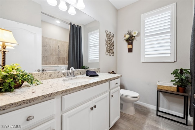 bathroom with vanity, toilet, and a tile shower