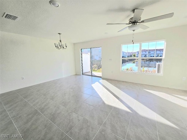 unfurnished room with light tile patterned flooring, ceiling fan with notable chandelier, and a textured ceiling