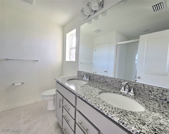 bathroom with vanity, toilet, tile patterned flooring, and a shower with door