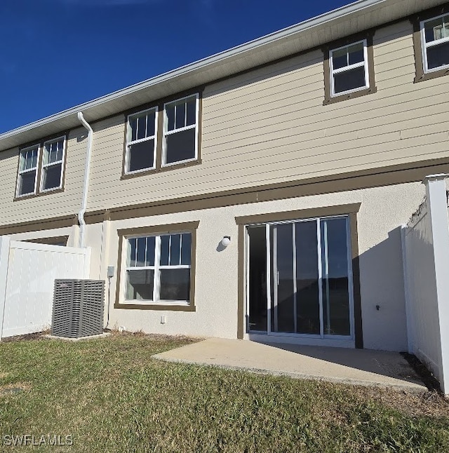 back of property with a patio, central AC unit, and a lawn