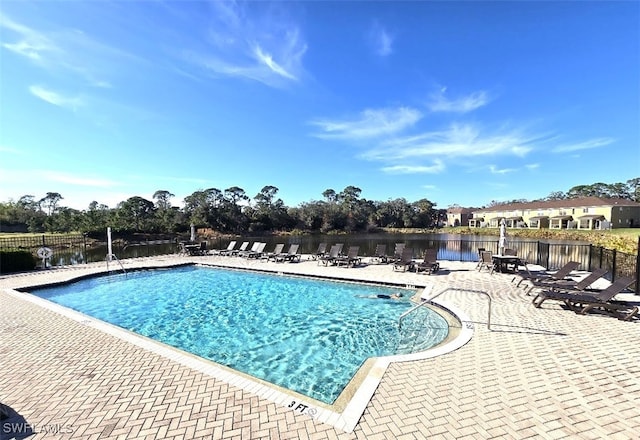 view of pool with a patio and a water view