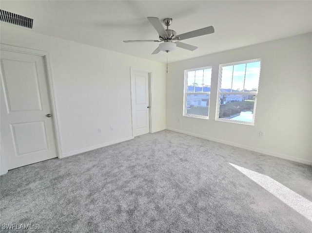 carpeted spare room with ceiling fan