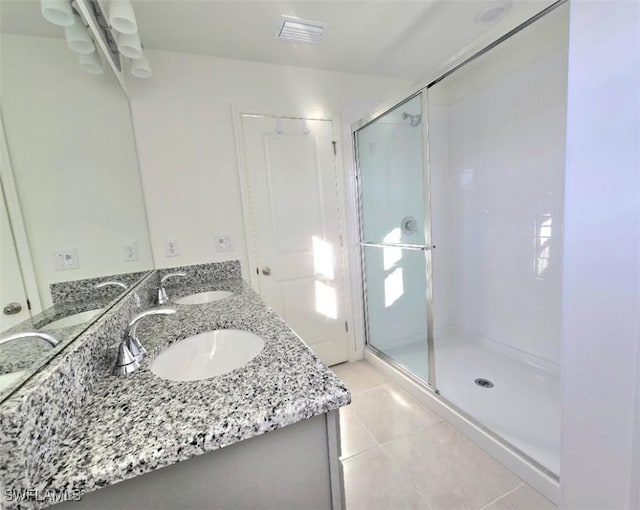 bathroom with vanity, a shower with shower door, and tile patterned flooring