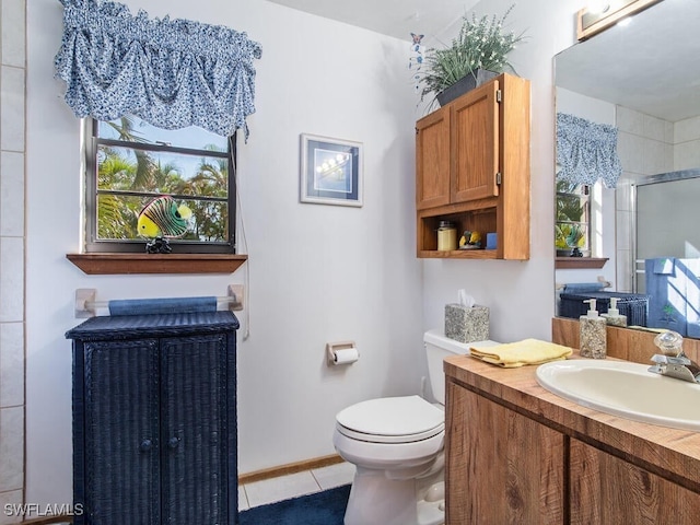 bathroom featuring tile patterned floors, toilet, a shower with shower door, and vanity