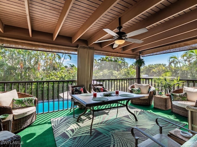 sunroom / solarium featuring ceiling fan and beam ceiling