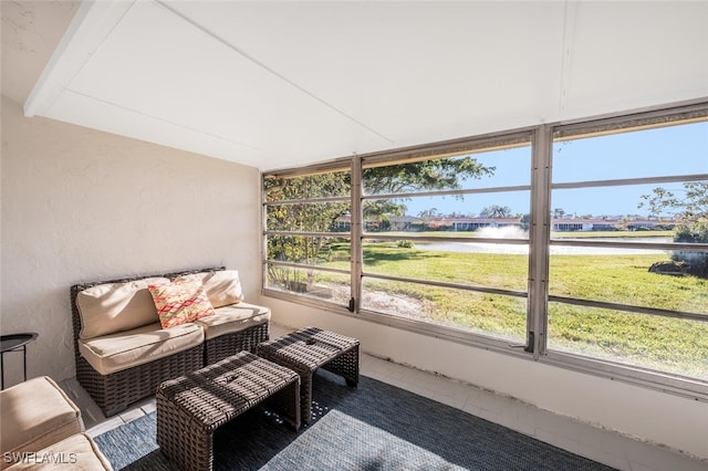 sunroom featuring a water view