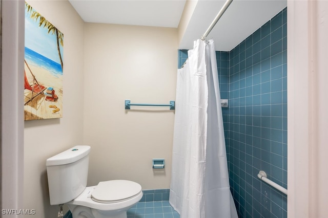 bathroom with a shower with curtain, tile patterned floors, and toilet