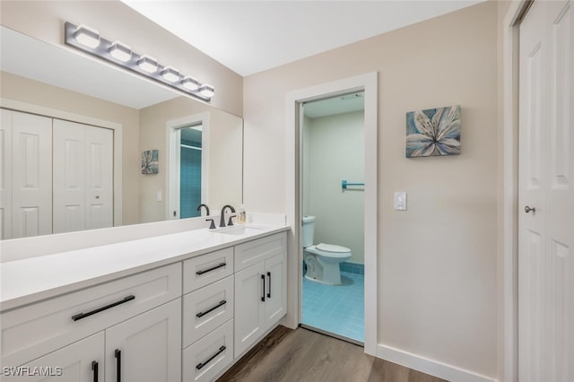 bathroom with vanity, hardwood / wood-style flooring, and toilet