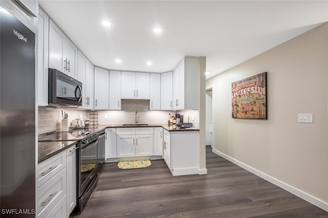 kitchen with appliances with stainless steel finishes, sink, white cabinets, and decorative backsplash