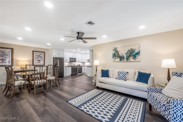 living room with dark wood-type flooring and ceiling fan