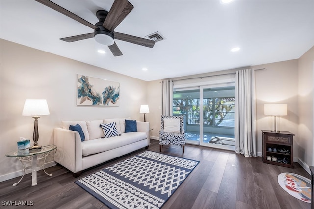 living room with dark wood-type flooring and ceiling fan