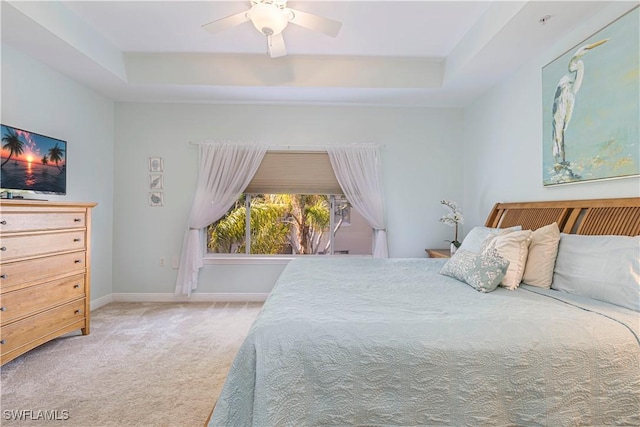 bedroom with carpet, ceiling fan, and a tray ceiling