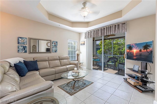 tiled living room featuring a tray ceiling and ceiling fan