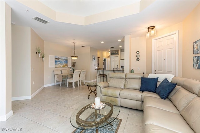 tiled living room featuring a raised ceiling